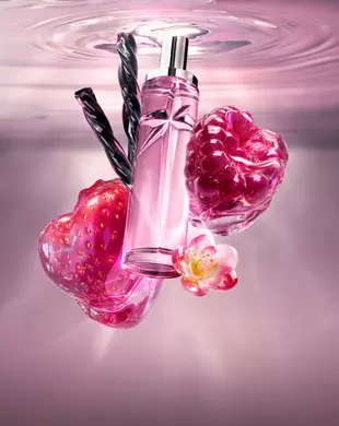 Nature morte du nouveau Starlicious Berry Licorice mettant en scène le flacon en verre élancé entouré de ses ingrédients clés : une fraise rouge brillante, une framboise éclatante, une fleur rose délicate et des bâtonnets de réglisse noirs torsadés, sur un fond d’eau ondulante rose tendre.